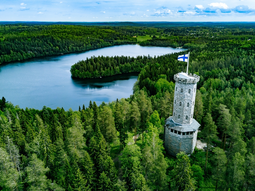 Aerial,View,Of,Observation,Tower,With,Finnish,Flag,Among,Blue